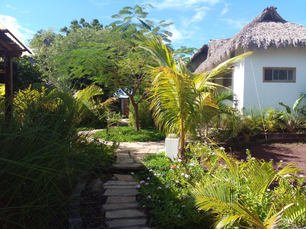 einen Weg zu einem Haus mit Strohdach in der Unterkunft TwoTen° Surf Home in Popoyo