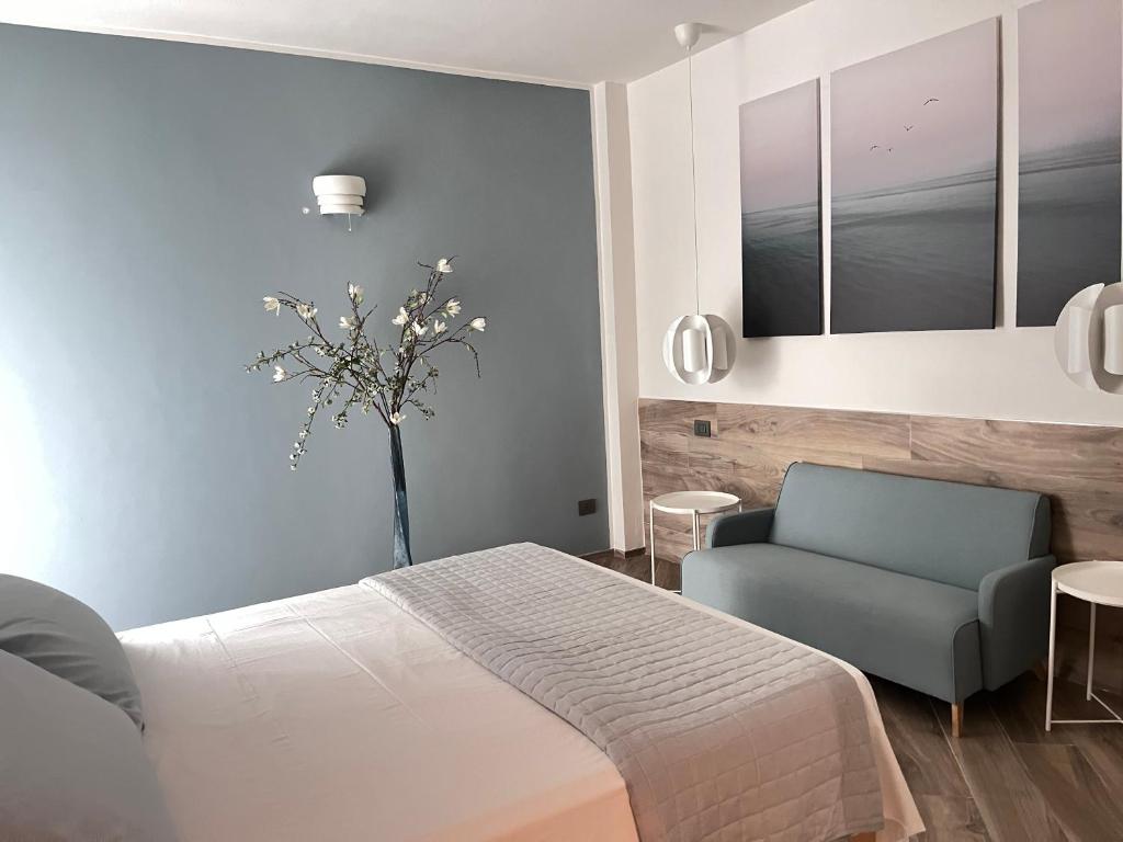 a bedroom with a bed and a blue chair at Strandhaus San Sebastiano in Spotorno