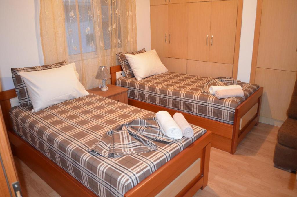 duas camas num pequeno quarto com em Maria Apartment em Gjirokastër