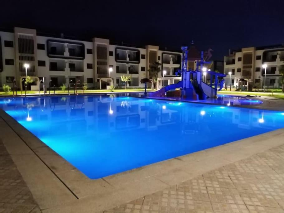 a large blue swimming pool at night at Résidence flambant neuve 5min à pied de la plage in Saïdia