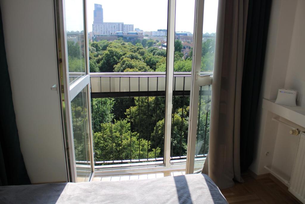 a bedroom with a large window with a view at Strict center Warsaw comfortable apartment, 10th-floor with beautiful view on the park and skyscrapers, free WiFi, self check-in/out in Warsaw