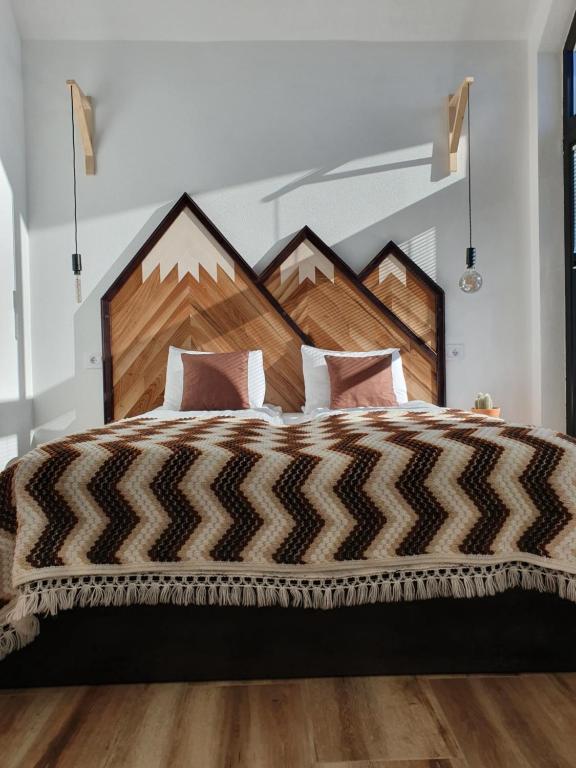 een slaapkamer met een groot bed met een houten hoofdeinde bij Smeštaj Skuratenko in Malo Laole