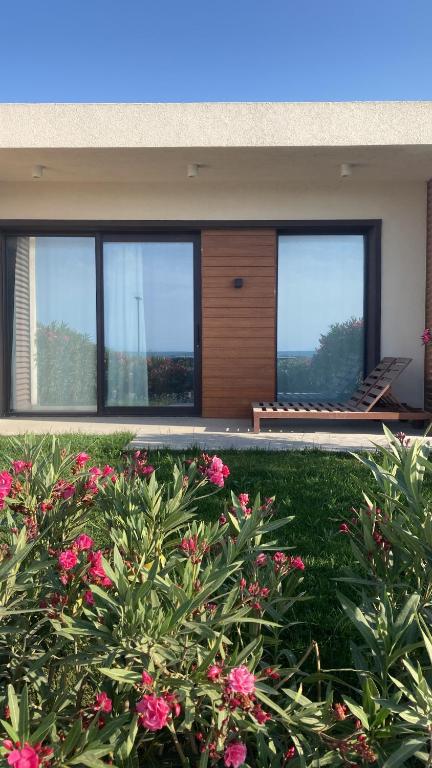 una casa con ventanas y flores en un patio en Sea Breeze Resort, White Villa, Nardaran, en Baku