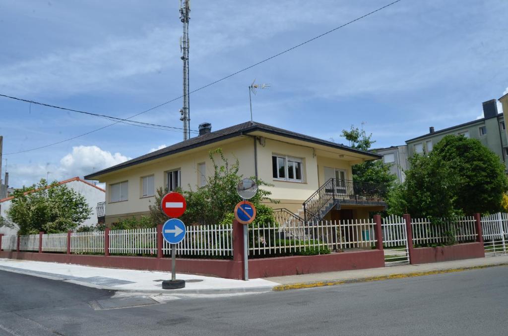 een geel huis met een hek ervoor bij Casa completa e independiente en centro de Melide in Melide
