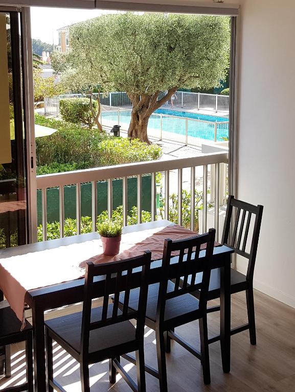 une table et des chaises de salle à manger avec vue sur un arbre dans l'établissement Les Embiez, à Six-Fours-les-Plages