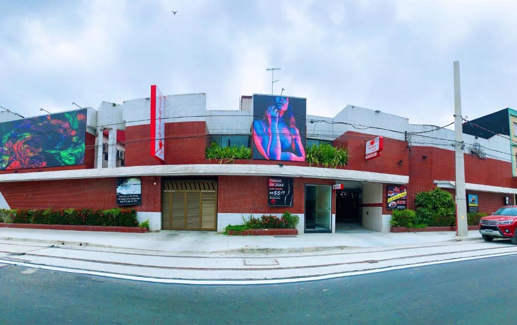 un edificio de ladrillo rojo con un cartel. en Studio Motel (Adult Only) en Santos