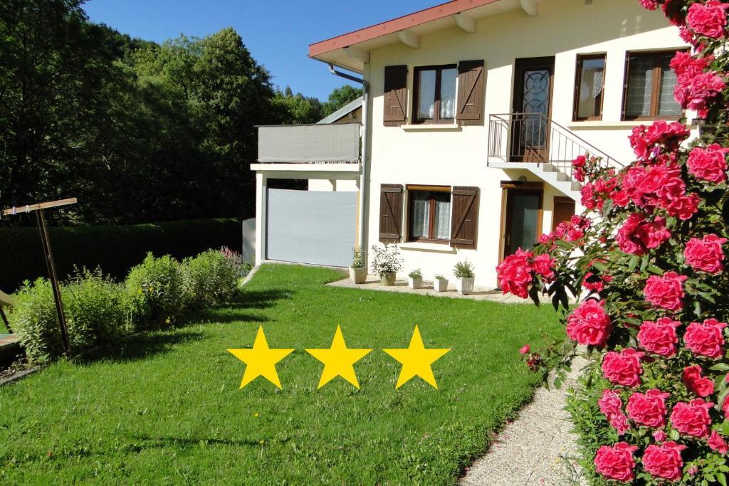 quatro estrelas amarelas no quintal de uma casa em Gîte 1805Bis Montagnes du Jura avec Spa et Sauna classé 3 étoiles em Foncine-le-Haut