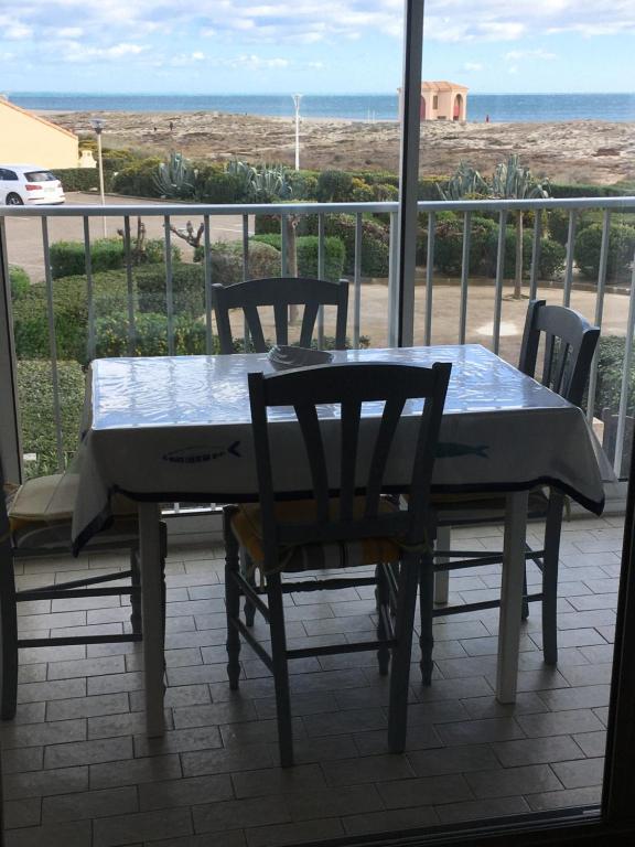 a table and chairs with a view of the beach at Appartement vue mer in Leucate