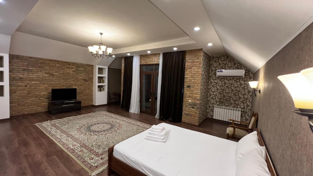 um quarto amplo com uma cama e uma lareira em Lite Guest House em Bishkek