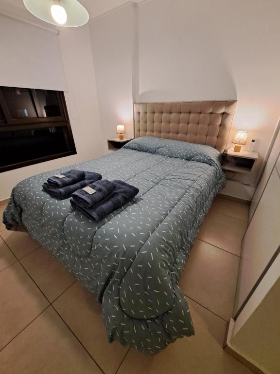 1 dormitorio con 1 cama con 2 toallas en Departamento Entero con Pileta Calasanzs en Córdoba