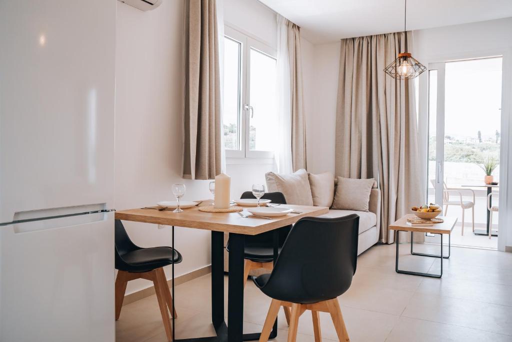 a kitchen and living room with a table and chairs at Grand White Apartments in Agios Ioannis