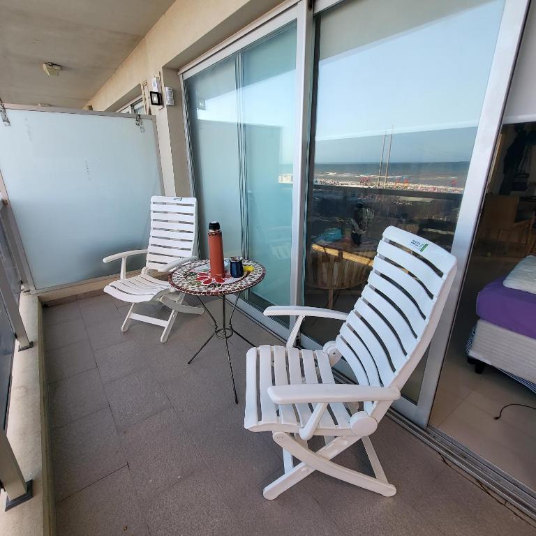 a balcony with two chairs and a table at Departamento Miranda in Villa Gesell