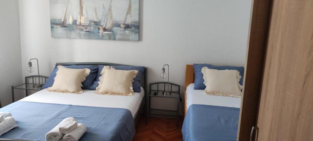 a bedroom with two beds with blue and white pillows at Apartman Campo in Šibenik