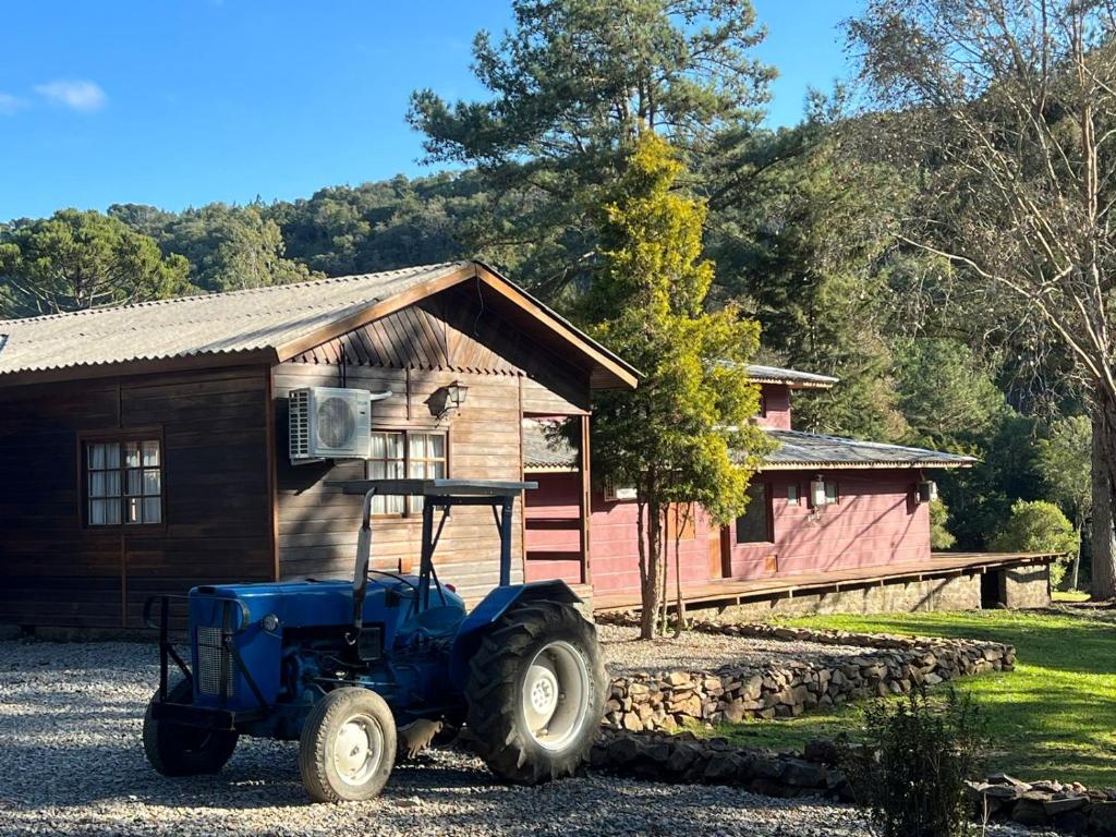 un trattore blu parcheggiato di fronte a una cabina di Hotel Cabanas Glamour a Gramado