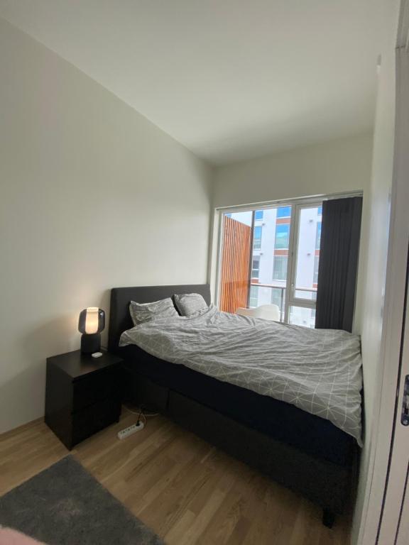 a bedroom with a bed and a window at Ny og moderne 2-roms leilighet på Øvre Nyhavna in Trondheim