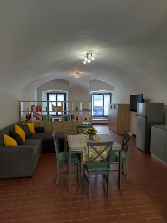 a living room with a couch and a table and chairs at La casina in città - The little flat in town in Alessandria