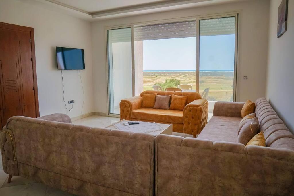 ein Wohnzimmer mit einem großen Sofa und Stühlen in der Unterkunft Apt 5min de la zone touristique in Hammamet