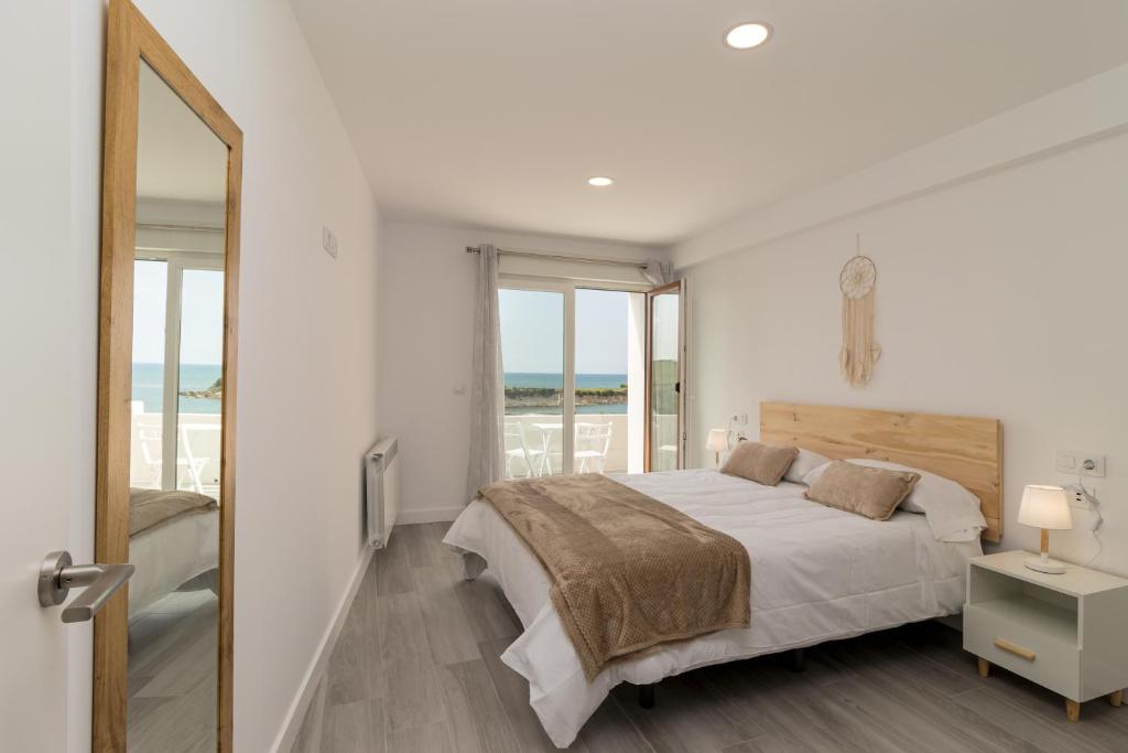 1 dormitorio con cama y vistas al océano en Precioso apartamento con espectaculares vistas, en Santander
