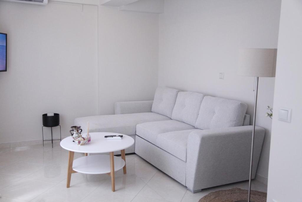 a living room with a couch and a table at Sea Front Retreat in Kavala