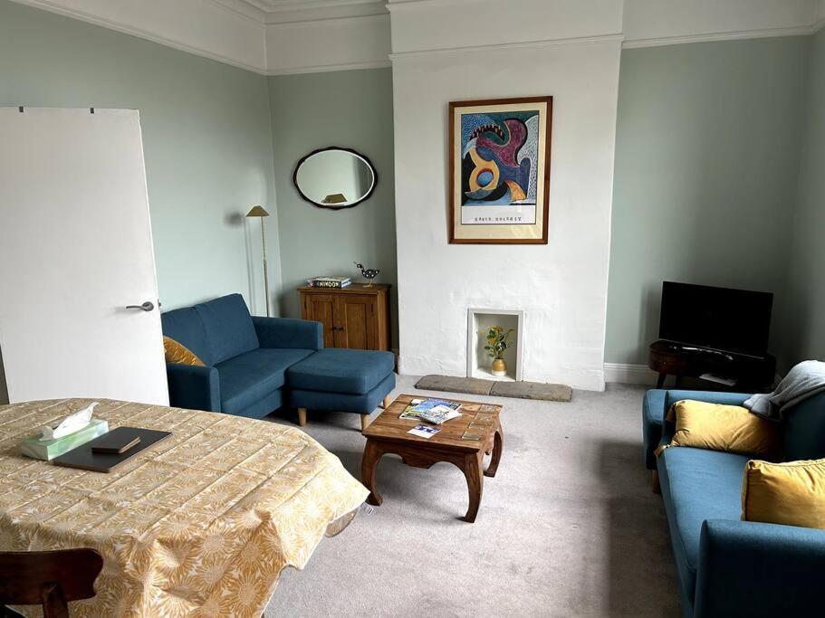 a living room with blue couches and a coffee table at Suze's Stays in Harrogate