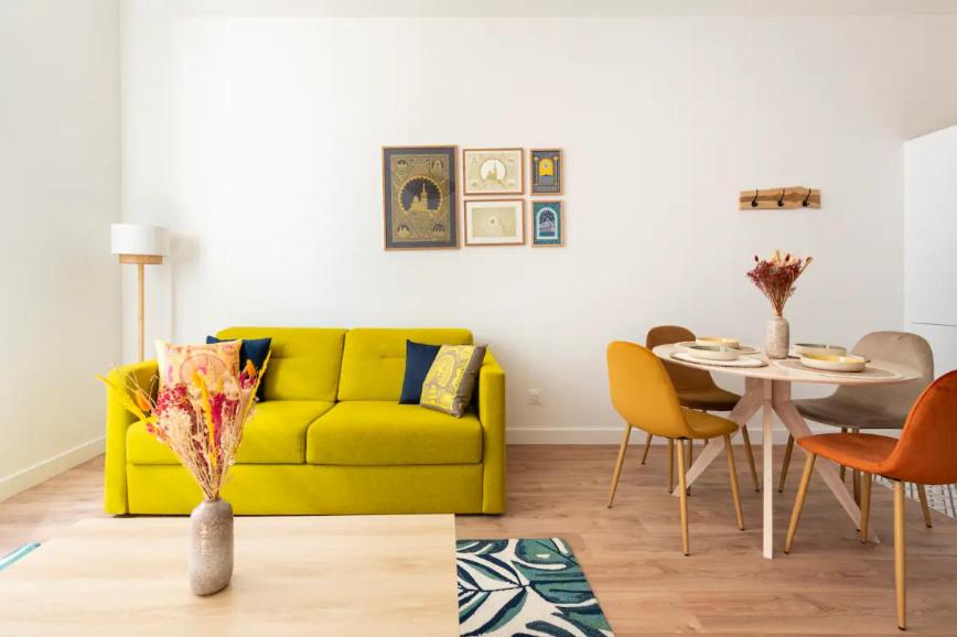 - un salon avec un canapé jaune et une table dans l'établissement {La petite Casà de Cézar} * Centre ville Marseille * Clim, à Marseille
