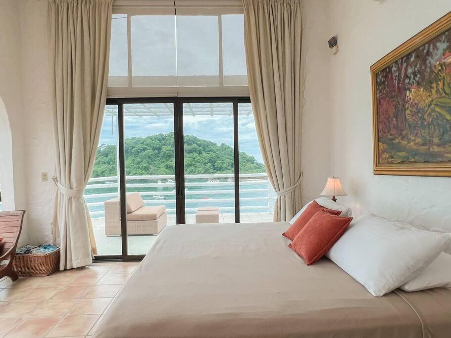 a bedroom with a bed with a view of the ocean at Live an adventure in Taboga 2 in Taboga