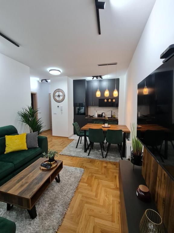 een woonkamer met een groene bank en een tafel bij Magic Apartman Zlatibor in Zlatibor