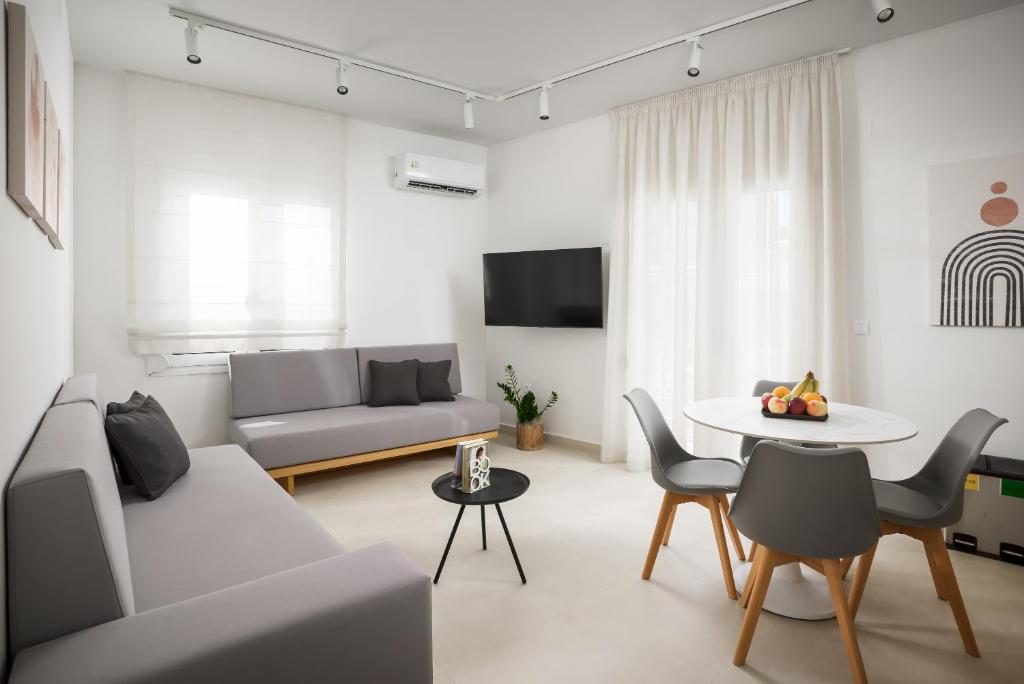 ein Wohnzimmer mit einem Sofa und einem Tisch in der Unterkunft The H Experience - Eclectic spacious apartment near Venetian Castle - 2 in Iraklio