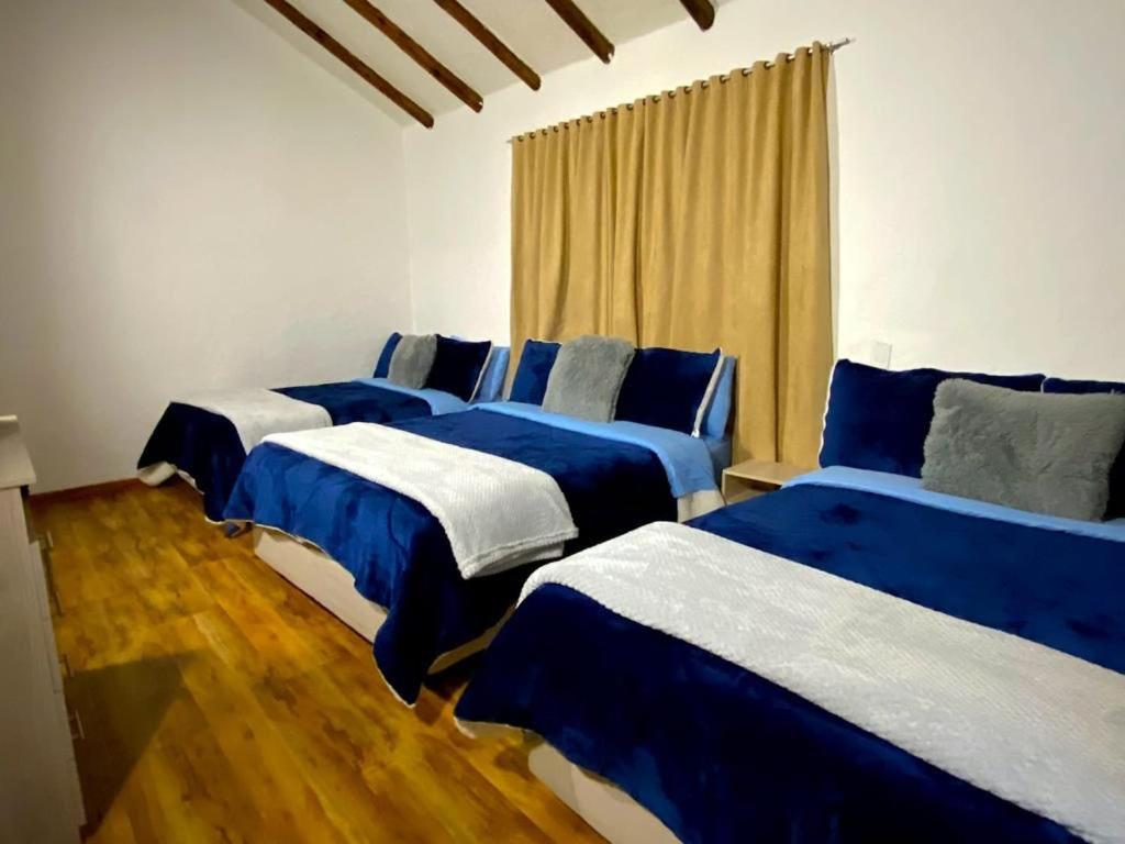 a group of four beds in a room at Hotel Niza Colonial in Bogotá