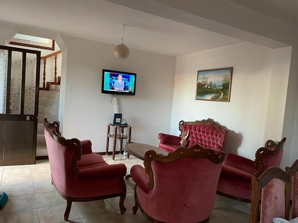 a living room with red chairs and a tv at Casa da Isilda ,three bedrooms in Estreito da Calheta