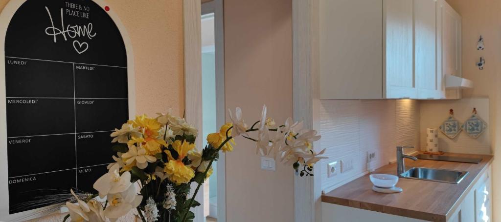 a kitchen with a vase of flowers in a kitchen at Karales Antica Dimora in Cagliari