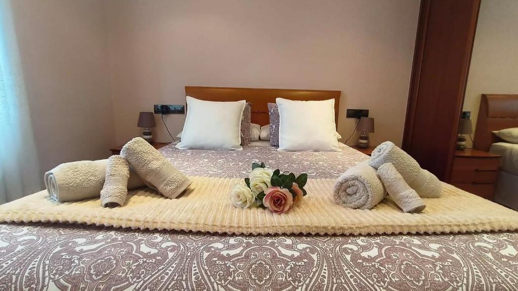 een bed met kussens en een boeket bloemen erop bij Arrantzale Beach in Bermeo