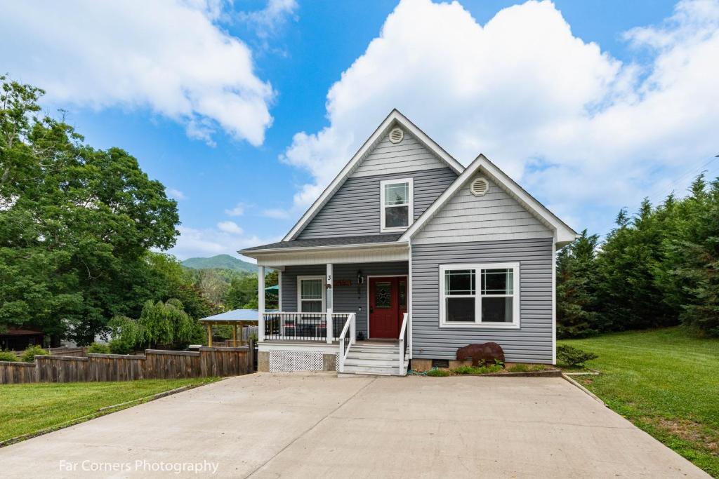 ein weißes Haus mit einer roten Tür und einer Einfahrt in der Unterkunft Mama Bears Blue Bungalow in Asheville