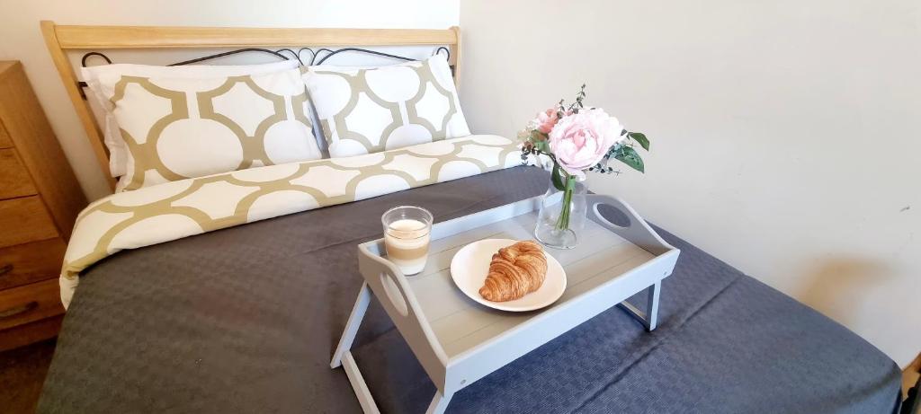 a bed with a table with a plate of food on it at Comfy 2 Bedroom Flat near Edinburgh City Center in Edinburgh
