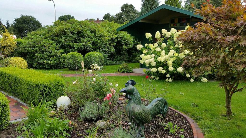 un jardín con una estatua de un pato en un jardín en Haus-Schiffer-Ferienwohnung-Lilli, en Rhauderfehn