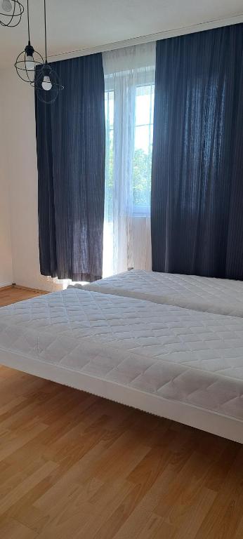 a large white bed in a room with a window at Gueshouse DaIris in Mostar
