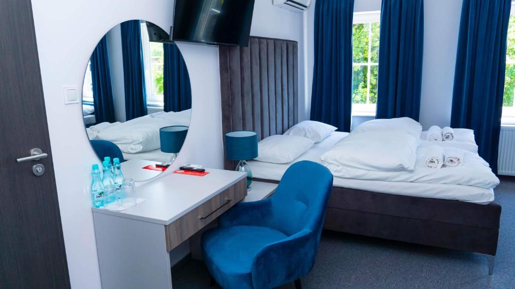 Habitación de hotel con cama y silla azul en Bon Żur, en Brzeg