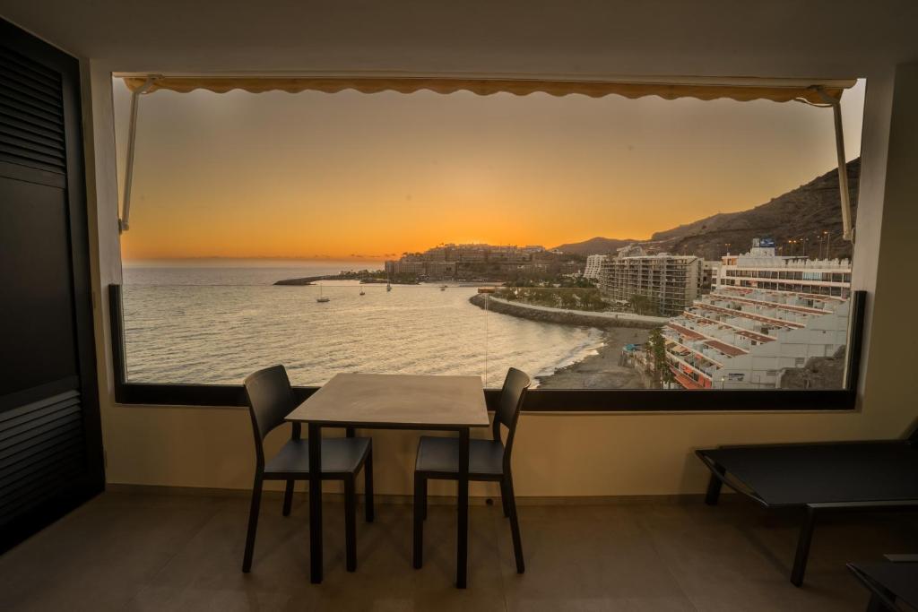 a table and chairs in a room with a view of the ocean at Sea Views Patalavaca in Patalavaca