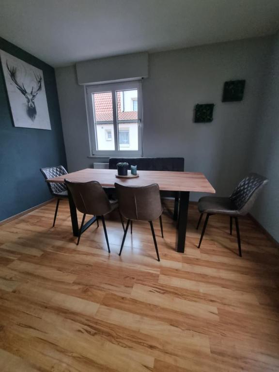 a dining room with a wooden table and chairs at Ferienwohnung zum Hufi in Dahn