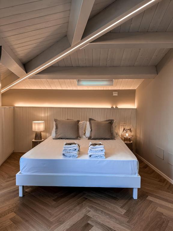 um quarto com uma cama branca e 2 almofadas em B&B Palazzo Bruni - Dimora di Mare em Marina di San Vito