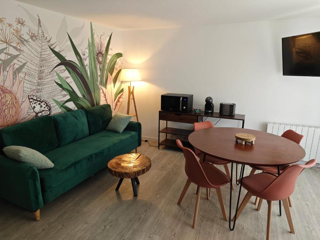 een woonkamer met een groene bank en een tafel bij Le nid de l'île in Amboise