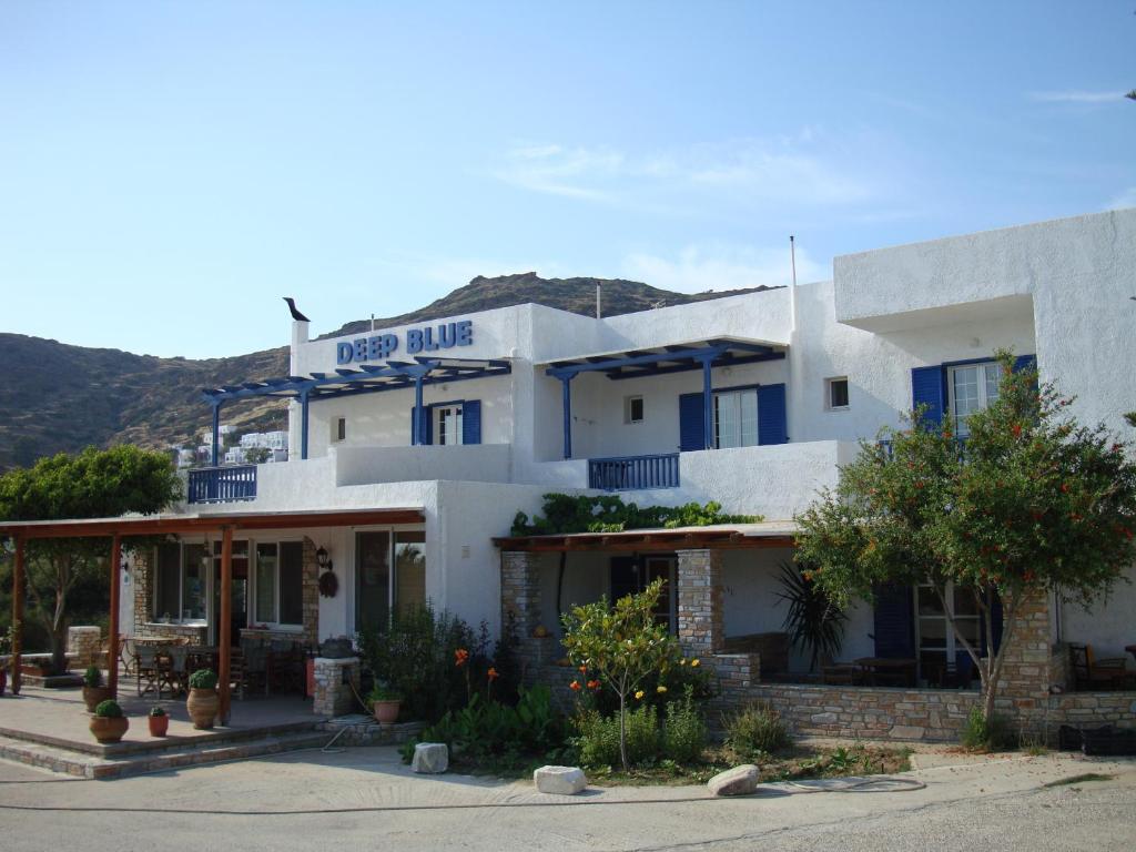 ein großes weißes Gebäude mit einem Schild drauf in der Unterkunft Deep Blue Rooms & Apartments in Mylopotas