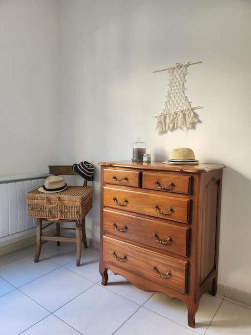 a dresser and a stool with a table and a chair at Villa à 10m de la plage de sable in Vallauris