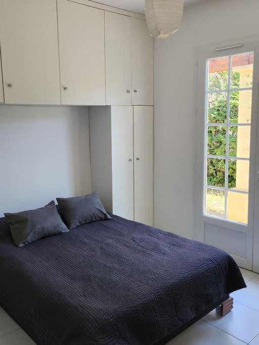 a bedroom with a blue bed and a window at Villa à 10m de la plage de sable in Vallauris