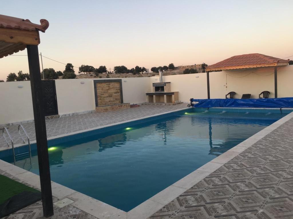 a swimming pool with blue water in a house at Poolside Perfection - Private Pool & BBQ in Irbid