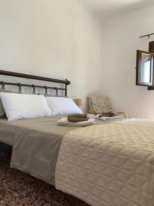 a bedroom with a large bed and a chair at Cactus villa in Karpathos Town