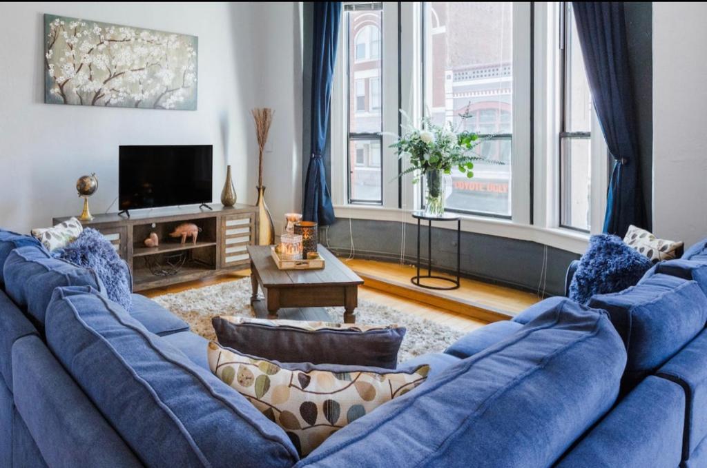 a living room with a blue couch and a tv at Greely Gaslamp - Loft W Parking & 3 Beds #202 in San Diego
