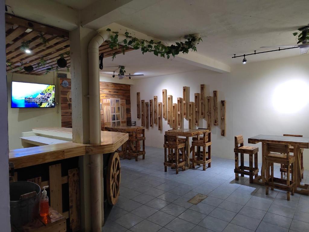 La Terraza Hostel في فلوريس: غرفة بها طاولات وكراسي خشبية في غرفة