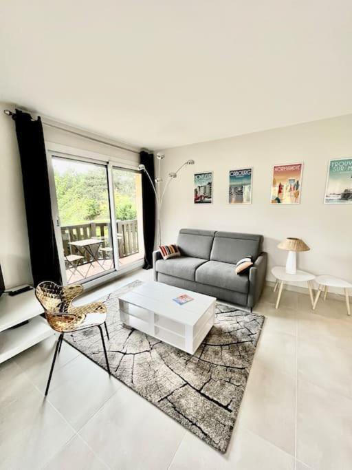 un salon avec un canapé et une table dans l'établissement Vacances paradisiaques à la plage, à Deauville