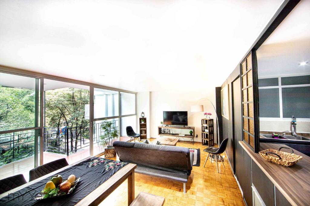 salon z kanapą i stołem w obiekcie Amsterdam - Deluxe Apartment with Furnished Balcony in La Condesa w mieście Meksyk